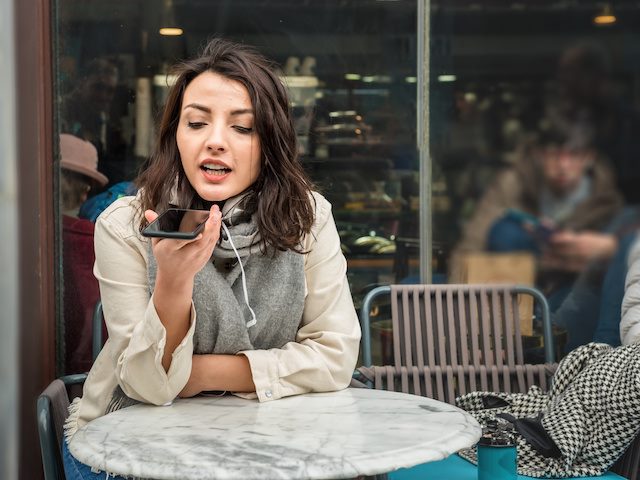 Woman speaking into phone at a cafe