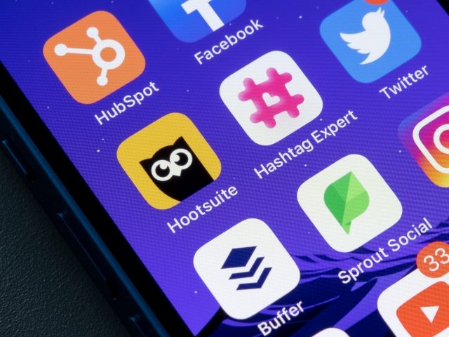 A phone screen shows several social media platforms on the menu. 