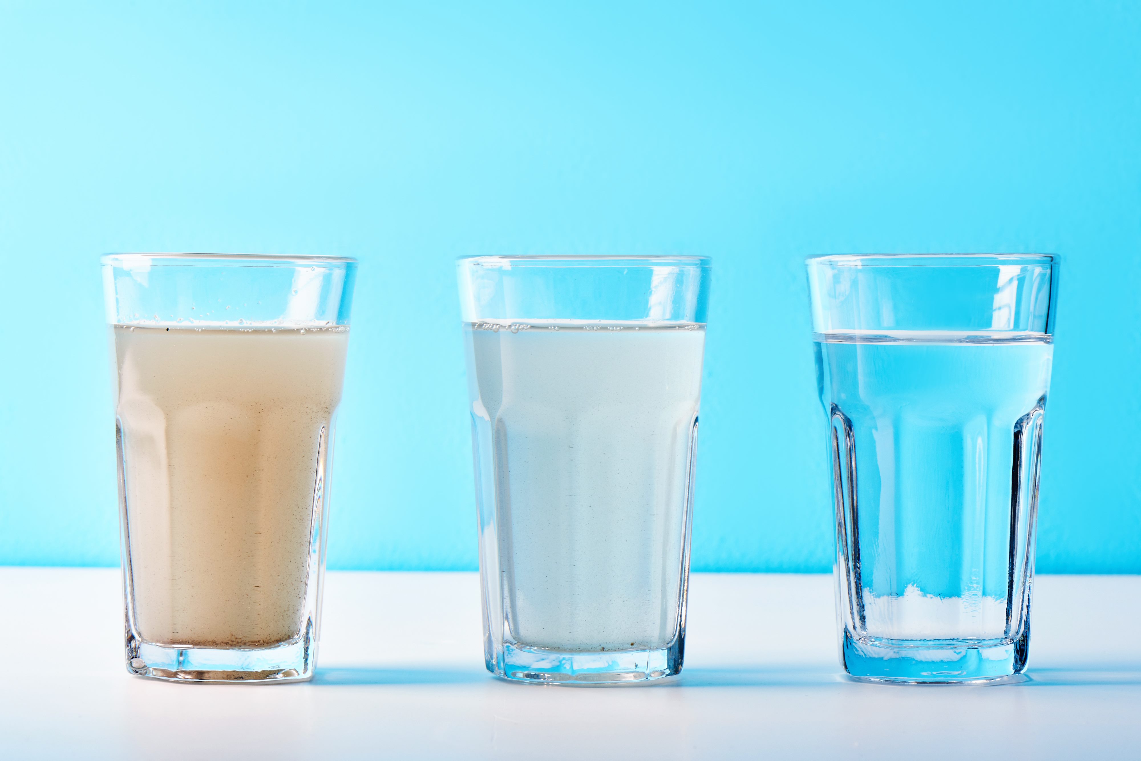 Three glasses of water of varying cleanliness