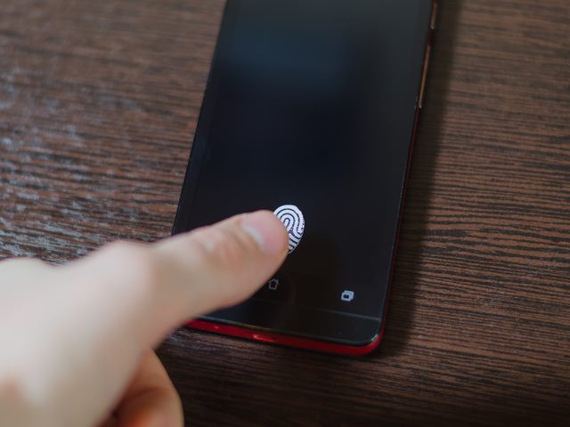 A person using their fingerprint to unlock a smartphone