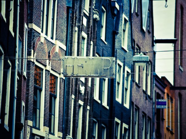 street sign hanging off of building reading "help"