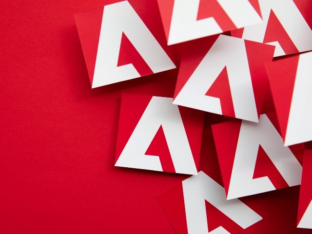 White Adobe logo tiles against bright red background.