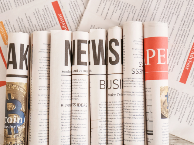 newspapers rolled up sitting next to each other. each roll has a letter. all of the rolls spell news - Newsbyte concept