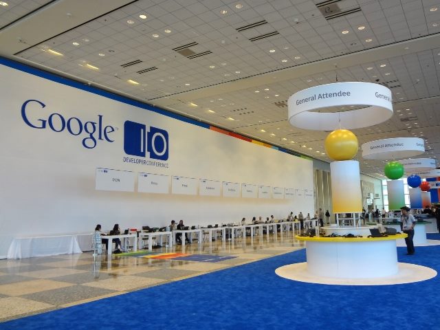 Scene from a past Google I/O. Registration, common-hallway walking area with a Google I/O label on the wall.
