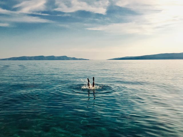 person diving headfirst into water